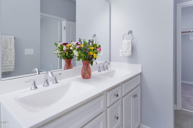 full bath featuring double vanity, baseboards, and a sink