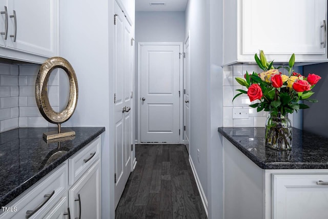 interior space featuring visible vents, dark wood-style floors, and baseboards