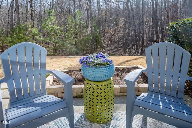 view of patio featuring a gate and a wooded view