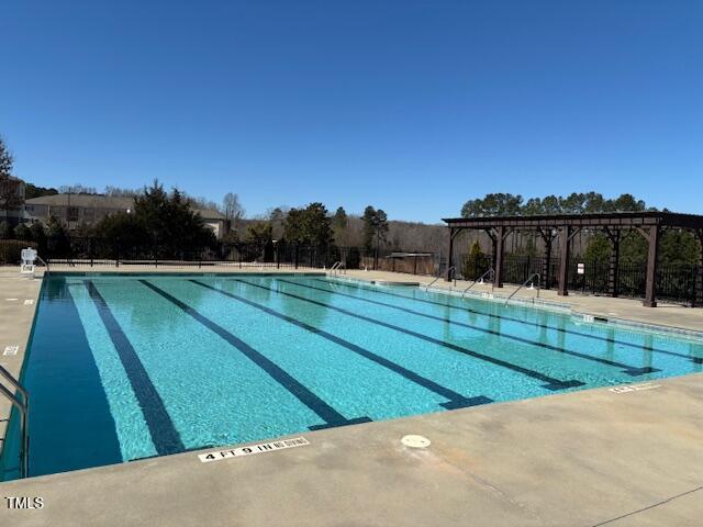 pool with a patio area and a pergola