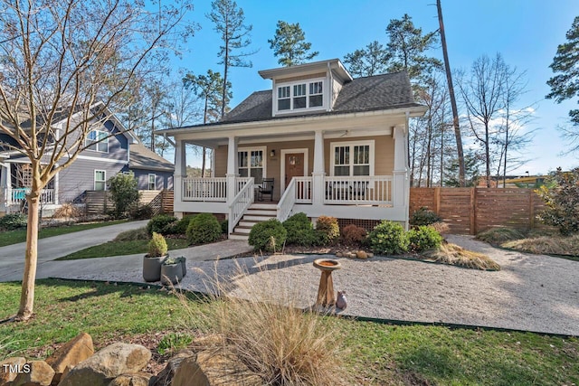 view of front of house with a porch, fence, and roof with shingles