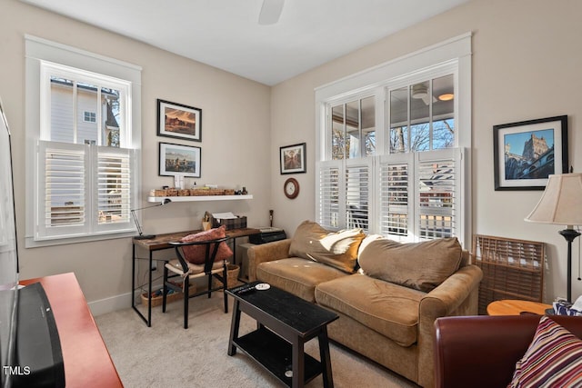 carpeted living area featuring baseboards, a wealth of natural light, and ceiling fan