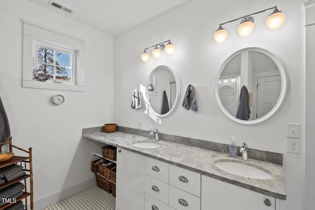 bathroom featuring a sink, visible vents, baseboards, and double vanity