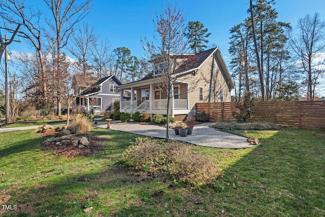 view of home's exterior featuring a yard, a porch, and fence