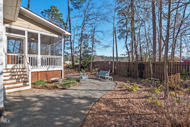 view of yard featuring a patio area, fence, and a sunroom