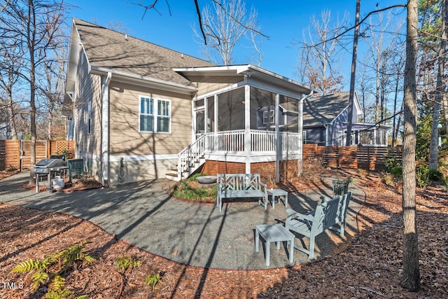 back of house with a patio, fence, a sunroom, a shingled roof, and stairs