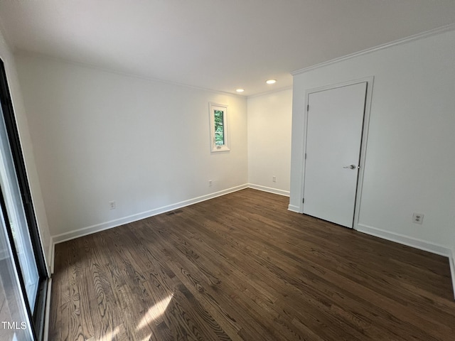 spare room with dark wood-style floors, visible vents, baseboards, and recessed lighting