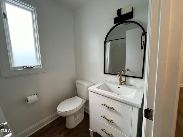 bathroom featuring curtained shower, toilet, wood finished floors, vanity, and baseboards