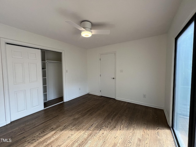 unfurnished bedroom featuring dark wood-style floors, a closet, and baseboards