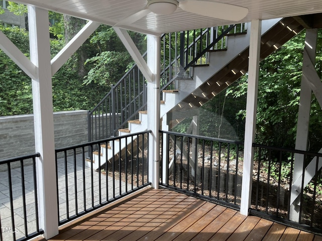 wooden terrace with a ceiling fan and stairs