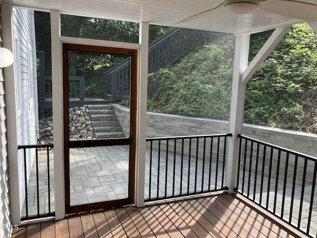 unfurnished sunroom featuring a ceiling fan