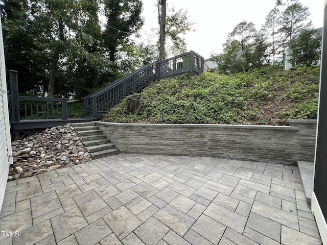 view of patio featuring a wooden deck and stairs