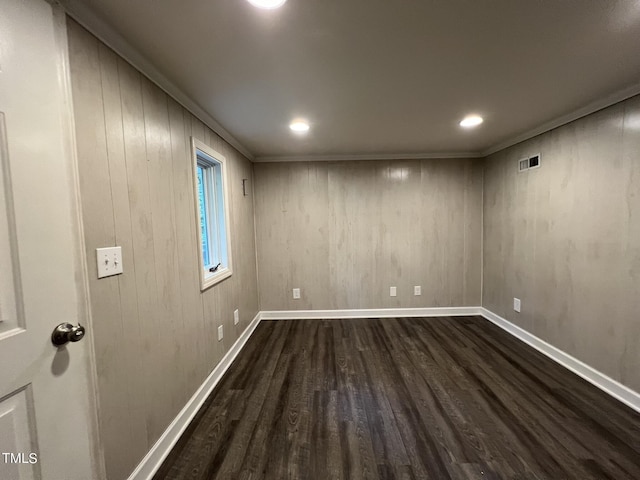 basement with dark wood-style floors, crown molding, recessed lighting, visible vents, and baseboards