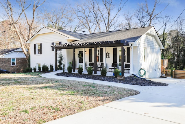 view of front of property with a front lawn, a porch, and roof with shingles