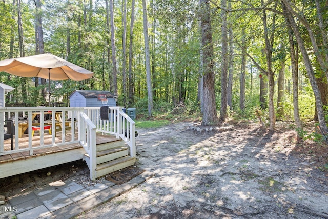 view of yard featuring a storage unit, a deck, and an outbuilding