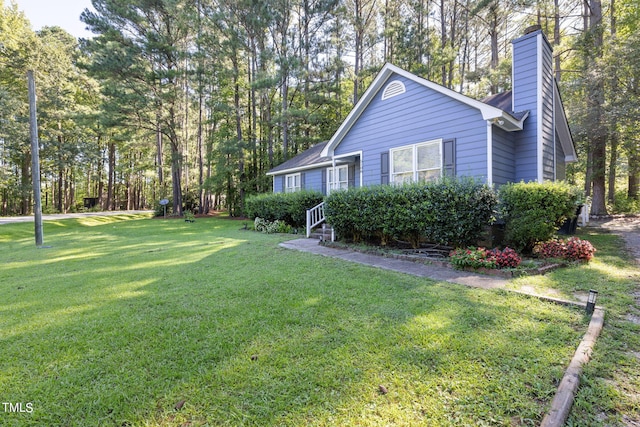 exterior space with a chimney and a yard