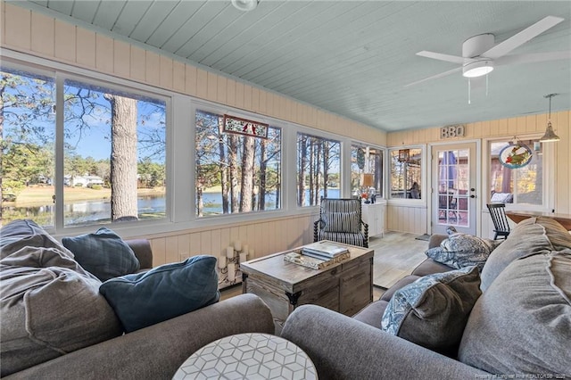 sunroom / solarium with a water view, wood ceiling, and a ceiling fan