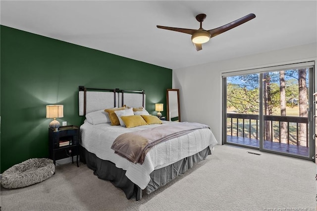 carpeted bedroom featuring access to outside, visible vents, and a ceiling fan