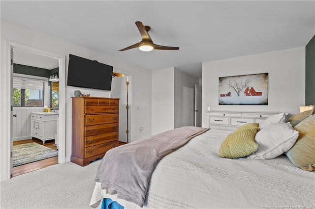 bedroom with ceiling fan, connected bathroom, and light colored carpet