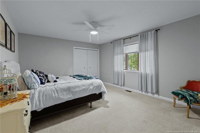 carpeted bedroom featuring visible vents, a closet, a ceiling fan, and baseboards