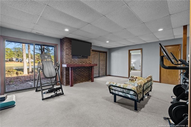 exercise room featuring light carpet, baseboards, a paneled ceiling, and recessed lighting