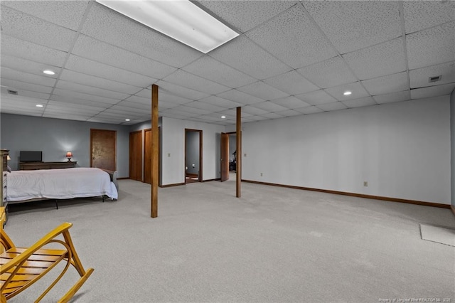 carpeted bedroom featuring baseboards, a drop ceiling, and recessed lighting