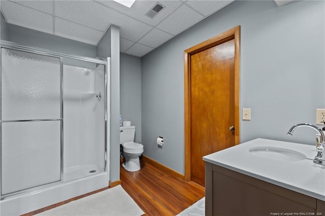 full bathroom with a drop ceiling, wood finished floors, visible vents, vanity, and a shower stall