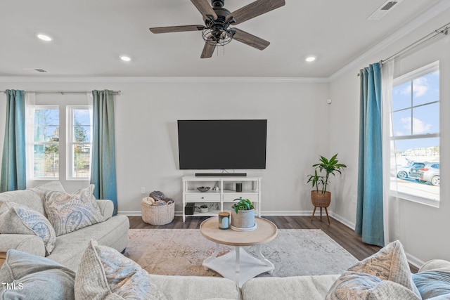 living area featuring dark wood-style floors, baseboards, visible vents, and crown molding