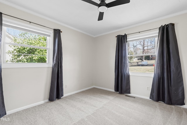 empty room with ornamental molding, light colored carpet, visible vents, and baseboards