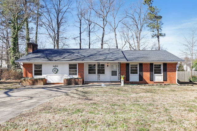 single story home featuring brick siding, a chimney, a shingled roof, a front yard, and fence