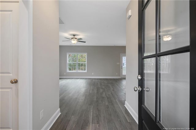 corridor with baseboards and dark wood-type flooring