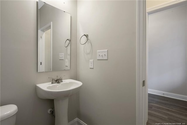 bathroom featuring wood finished floors, toilet, and baseboards