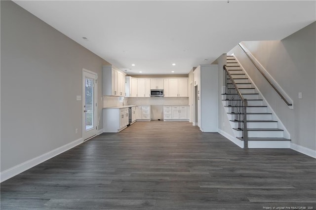 kitchen with stainless steel appliances, baseboards, white cabinets, light countertops, and dark wood-style floors