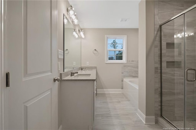 full bathroom featuring a sink, baseboards, a bath, double vanity, and a stall shower