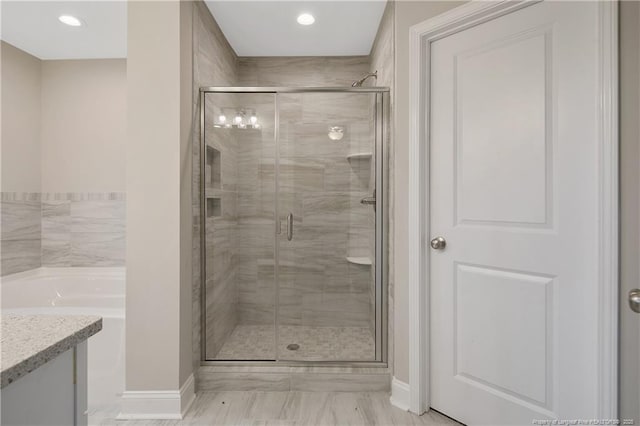 bathroom featuring a stall shower, vanity, and baseboards