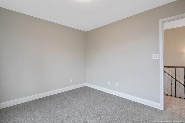 unfurnished room featuring carpet floors and baseboards