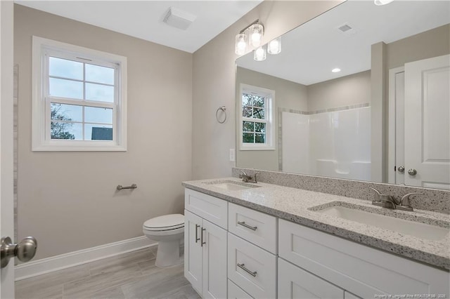 full bath featuring visible vents, a sink, and baseboards