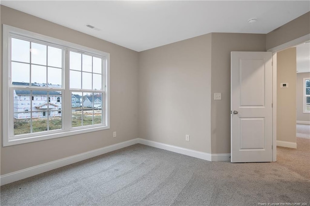 empty room with visible vents, baseboards, and carpet flooring