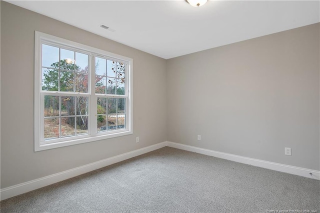 carpeted empty room with visible vents and baseboards