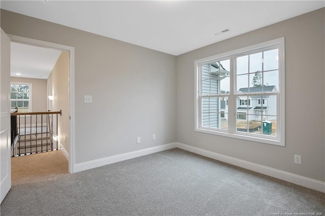 unfurnished room with carpet floors, plenty of natural light, and baseboards