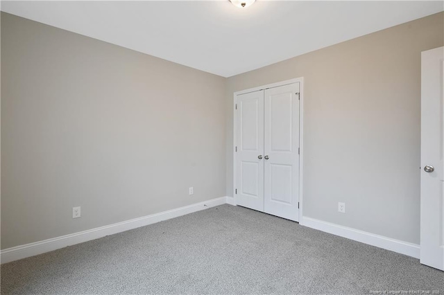 unfurnished bedroom featuring a closet, carpet flooring, and baseboards