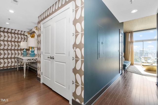 hallway with recessed lighting, wood finished floors, visible vents, and wallpapered walls