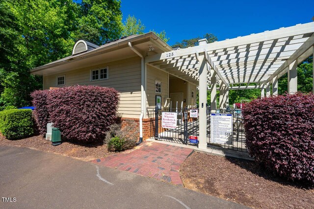203 E Winmore Ave, Chapel Hill, NC 27516 - view of side of home with a pergola, brick siding, and a gate