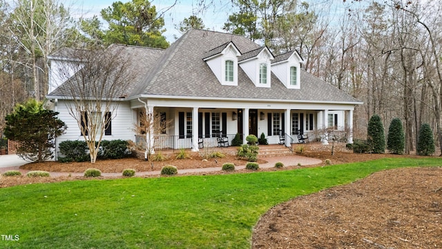 cape cod house with a porch, a shingled roof, and a front lawn