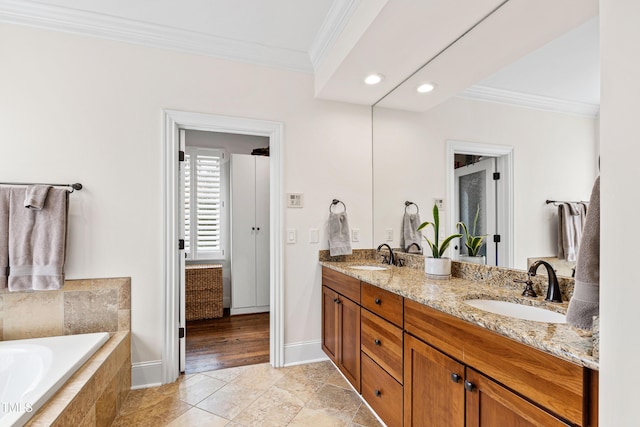 bathroom featuring double vanity, tiled bath, crown molding, and a sink