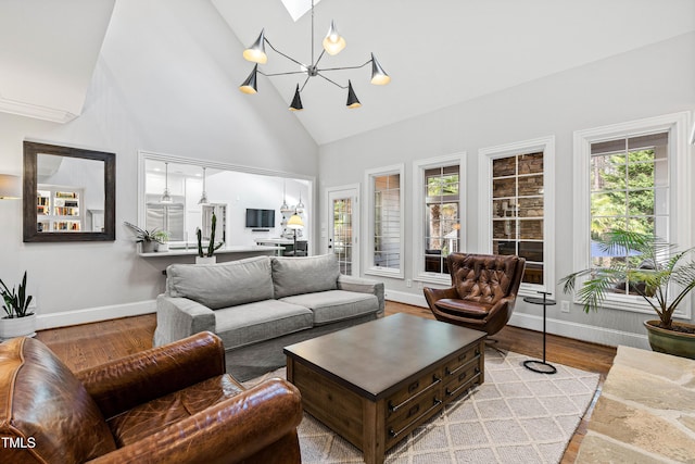 living room with baseboards, high vaulted ceiling, and wood finished floors