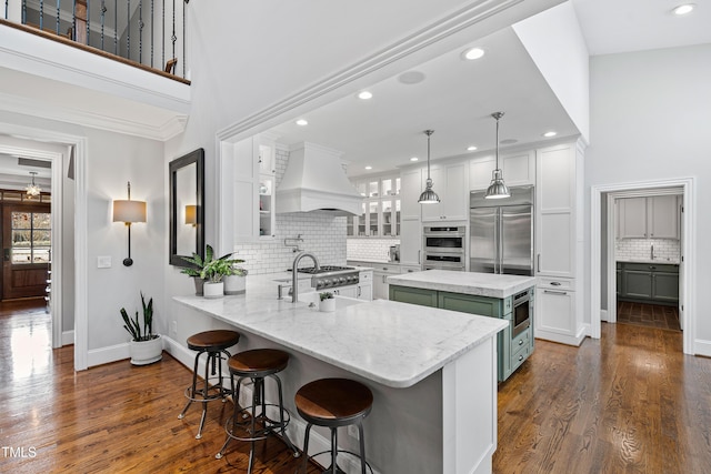 kitchen featuring premium range hood, a sink, dark wood finished floors, white cabinetry, and built in appliances