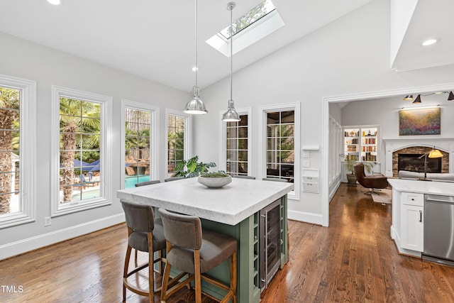 kitchen featuring beverage cooler, plenty of natural light, white cabinets, and stainless steel dishwasher