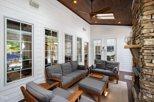 sunroom / solarium with wood ceiling, a ceiling fan, and vaulted ceiling