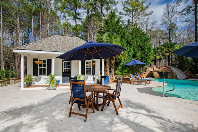 pool with outdoor dining space, a patio, and a water slide